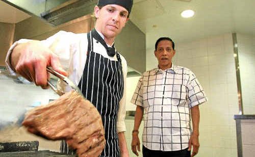 Seagulls new head chef Sylvester Courtinho watches chef Matt Hamilton grill a steak.